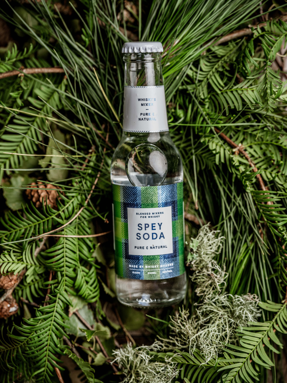 Spey Soda Pure & Natural whisky mixer bottle resting on pine needles